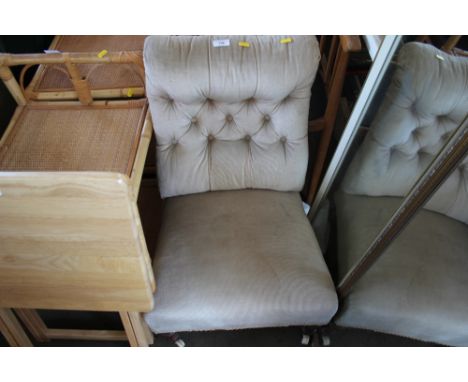 A button back nursing chair raised on turned supports