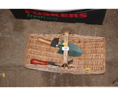 A gardeners trug and a small fork and spade