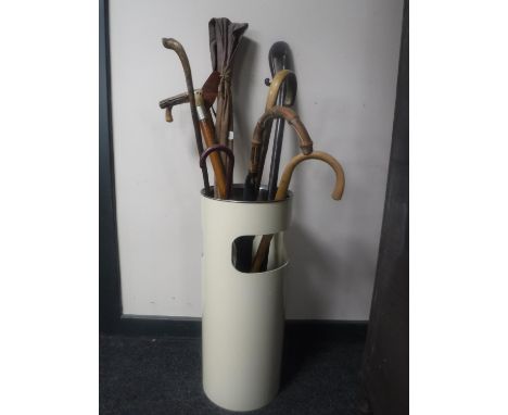 A waste paper bin containing walking sticks, parasols, vintage Hardy fishing rod in bag