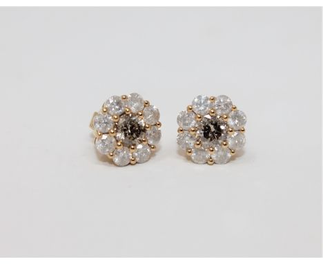 A pair of 18ct yellow gold diamond stud earrings featuring two round brilliant cut cognac diamonds 1.101ct with 16 round bril