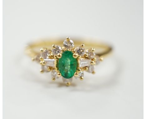 A modern 18ct gold, single stone oval cut emerald and round and trapeze cut diamond set cluster ring, size M, gross weight 2.