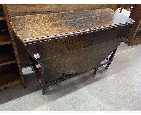 An early 18th century oak oval topped gate leg dining table, width 120cm, depth 45cm, height 71cm