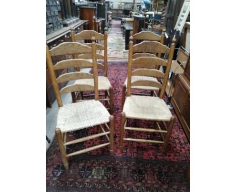 A set of four oak rush seat ladder back dining chairs.