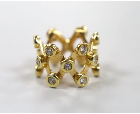 A modern yellow metal and diamond cluster set lattice work dress ring, size L/M, gross weight 12.7 grams.