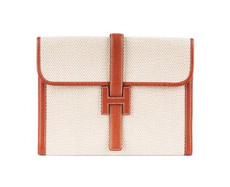 Hermes, a 2003 rare vintage Jige GM clutch, crafted from beige toile canvas with tan leather trim, featuring a top flap closu
