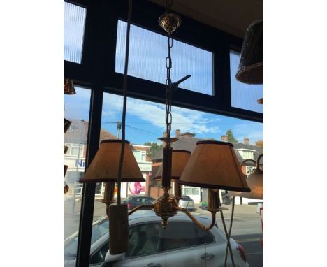 A three-arm gold and burgundy chandelier with a cream and burgundy parchment shades, 3 x bayonet candle bulb, compatible with