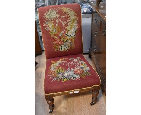 Victorian Nursing Chair With walnut frame brass casters and tapestry fabric bearing embroidery of flowers to seat and back