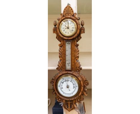 A good wall barometer and clock, contained in a carved oak case. The clock has centre seconds and date. Dimensions 26" x 10" 