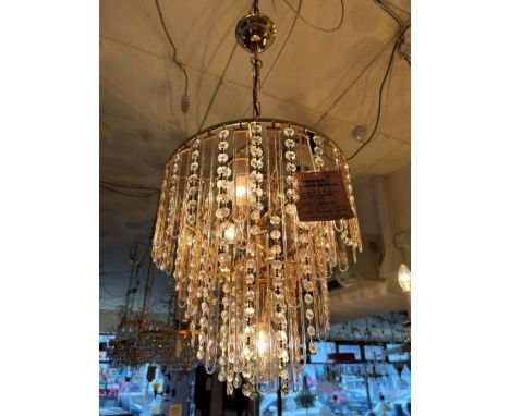 A four light pendant which consists of pink translucent strips and crystal beads all hanging on a gold plated twisted tiered 