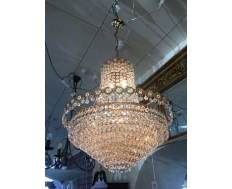 A seven light crystal chandelier on a gold plated circular tiered frame together with gold plated height adjustable chain, re