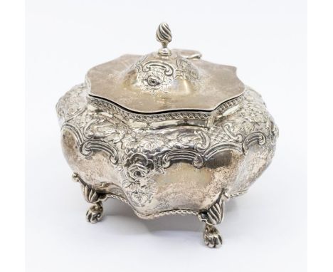 A Victorian silver embossed bombe shaped tea caddy and cover, on four paw feet, the shaped cover with flame finial, hallmarke