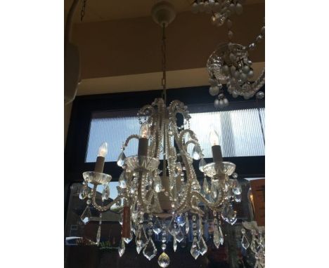 A six-light crystal and cream frame chandelier, the crystal beads are attached to the central cage and arms, there are six cl