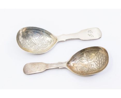 Two George IV silver fiddle pattern caddy spoons, both with engraved decoration to bowls (grapes or flowers), one with intial