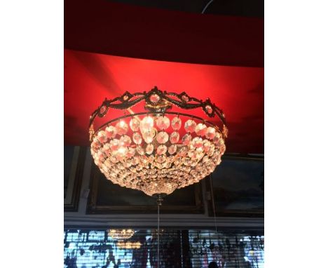 A four light crystal and gold-plated flush ceiling light, includes a carved gold finish outer frame and crystal beads that de