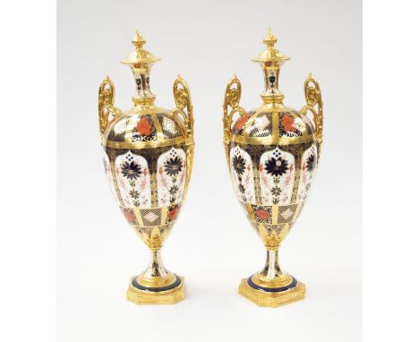 A pair of&nbsp;Royal Crown Derby 1128 Imari twin handled vases, heavily gold painted, one with crack to base, first quality