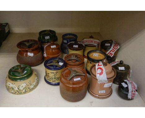 A collection of glazed Langley ware tobacco jars, decorated with daisies, in a green ground, another advertising tobacco, wit