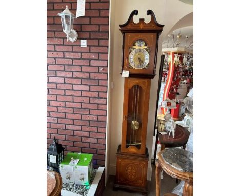 A mahogany cased grandfather clock with brass chains, pendulum and weights, the face detailing black roman numerals, one glas