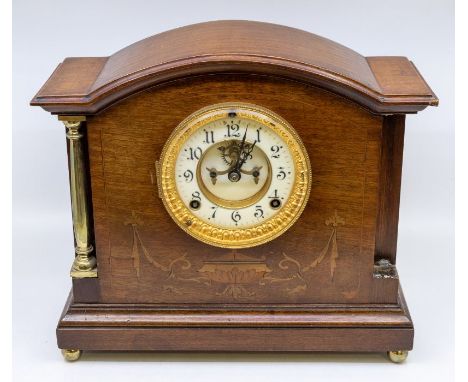 A mantle clock by the Ansonia Clock Company, with wooden case, enamel dial and brass column detail