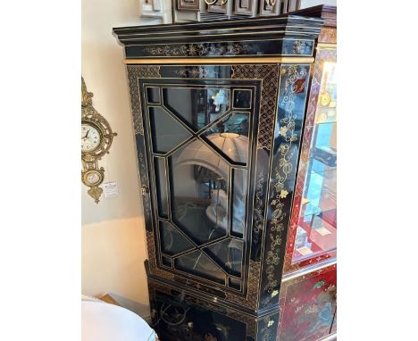 A single door black and gold lacquer corner display cabinet with bird detail to bottom section, the upper section having two 