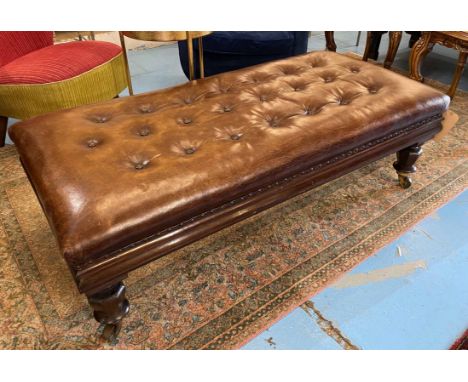 HEARTH STOOL, with buttoned brown leather upholstery on short faceted turned supports, 141cm W x 45cm H x 67cm D.