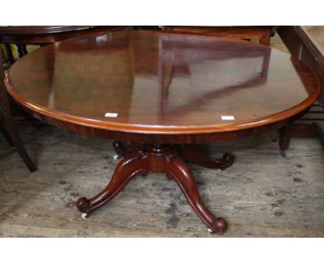 A Victorian mahogany oval dining table on quadrical supports with original ceramic casters