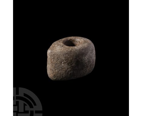 Late 4th millennium B.C. A black diorite axe head with central circular socket for attachment to an organic shaft, old inked 
