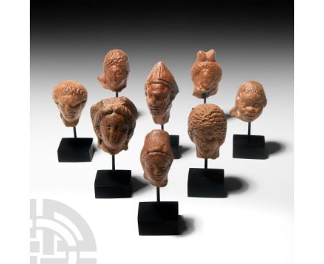 1st century B.C.-2nd century A.D. A group of votive terracotta figure heads comprising: a head of a priest wearing a conical 