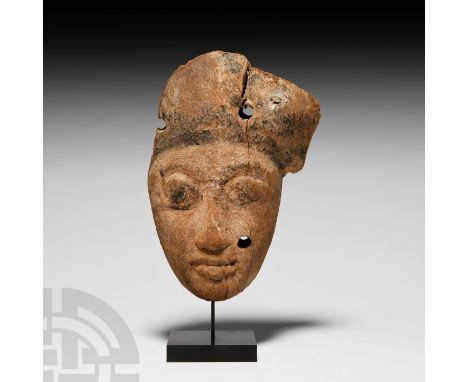 Roman Period, 30 B.C.-323 A.D. A carved wood mummy mask with remains of black painted semi-naturalistic facial detailing, low