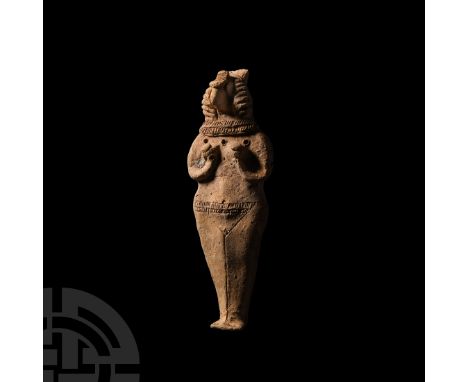 c.12th-8th century B.C. A ceramic fertility idol with stylised anatomical features, hands clasping full breasts, wearing neck