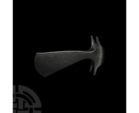 9th-11th century A.D. A triangular iron axehead with domed face to the circular socket and lateral wings, the blade with curv