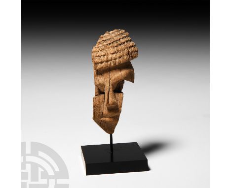 New Kingdom, 1550-1070 B.C. A fragment of a carved hard-wood face with semi-naturalistic detailing to the face and hair, seem