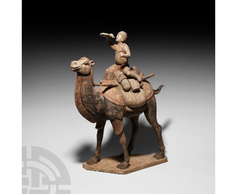 Tang Dynasty, 618-907 A.D. A ceramic figure modelled as a standing Bactrian camel on a flat irregular base, integral rider on