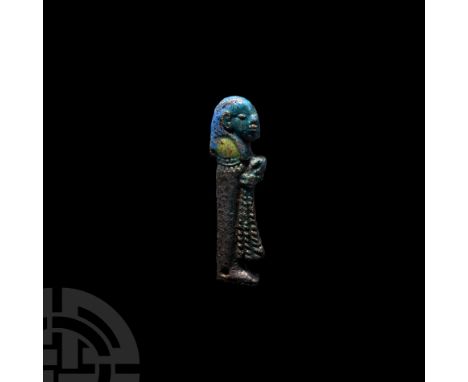 Third Intermediate Period, 1069-702 B.C. A blue-glazed male figure standing right, wearing a bag wig and holding a ribbed sas