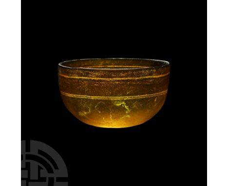 3rd-1st century B.C. An amber-coloured hemispherical glass bowl with circumferential rotary grinding marks on the interior, s