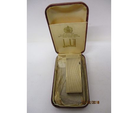 A Dunhill 9ct gold cased cigarette lighter 1962, of rectangular form with engine turned decoration, with paperwork in a red f
