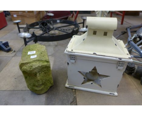 An outdoor wooden lantern and a carved stone head