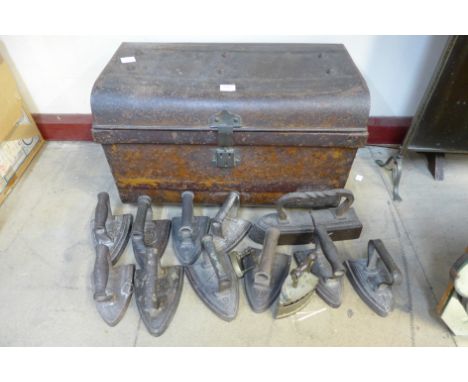 A tin trunk and cast iron flat irons