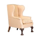 A MAHOGANY AND UPHOLSTERED WING ARMCHAIR IN GEORGE III STYLE