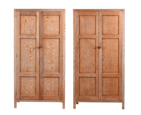 HEAL'S LONDON, A PAIR OF LIMED OAK WARDROBES  CIRCA 1920 Each with panelled doors enclosing a high shelf and hanging rail Wit