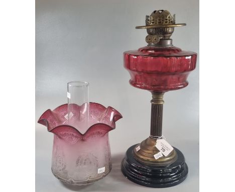 Early 20th century double oil burner lamp having cranberry and etched glass shade above a cranberry glass reservoir on a bras