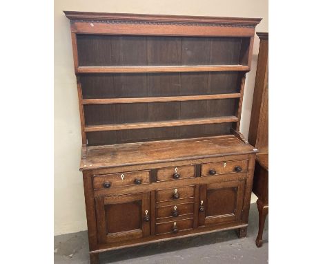 Early 19th century North Wales oak dresser with boarded three shelf rack back over a base of three cock beaded frieze drawers