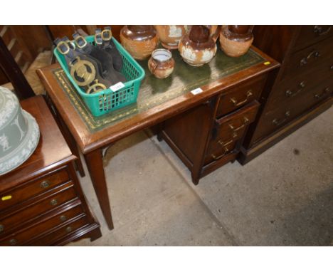 An oak and green leather topped writing desk fitted four drawers of small proportions