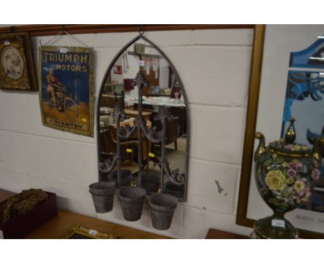 A metal arch framed wall mirror, attached with three planters 