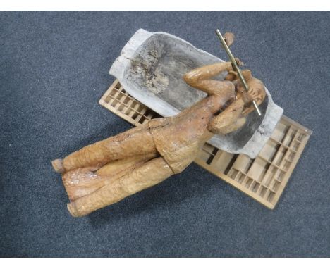 A carved wooden figure playing a flute, rustic dough trough and a printer's type drawer