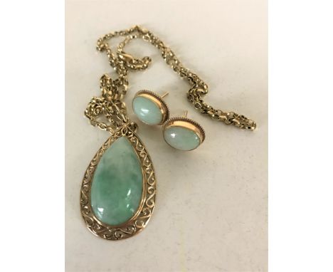 A jade pendant mounted in 9ct gold suspended upon a yellow metal chain with matching earrings. (3)
