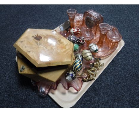 A trinket box of costume jewellery and a quantity of metal eggs on stands, pink glass dressing table set, clock and leaf dish