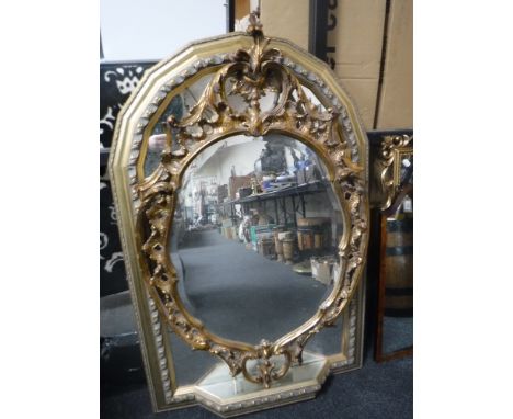 A gilt framed arched sectional mirror with shelf and a gilt Rococo style mirror 