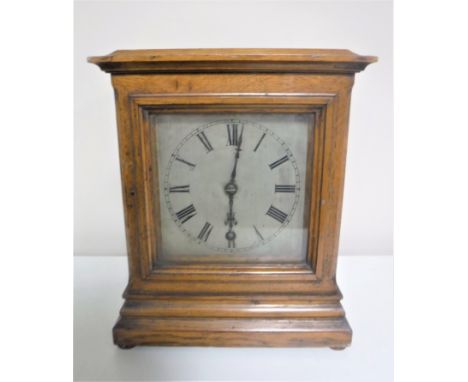 An early 20th century oak cased mantel clock with silvered dial