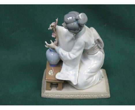 LLADRO GLAZED CERAMIC FIGURE OF A KNEELING GEISHA WITH FLOWERS, APPROXIMATELY 20cm HIGH 
