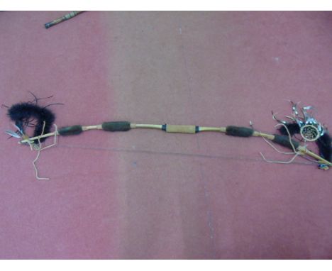 A tribal bow with fur and feather decoration